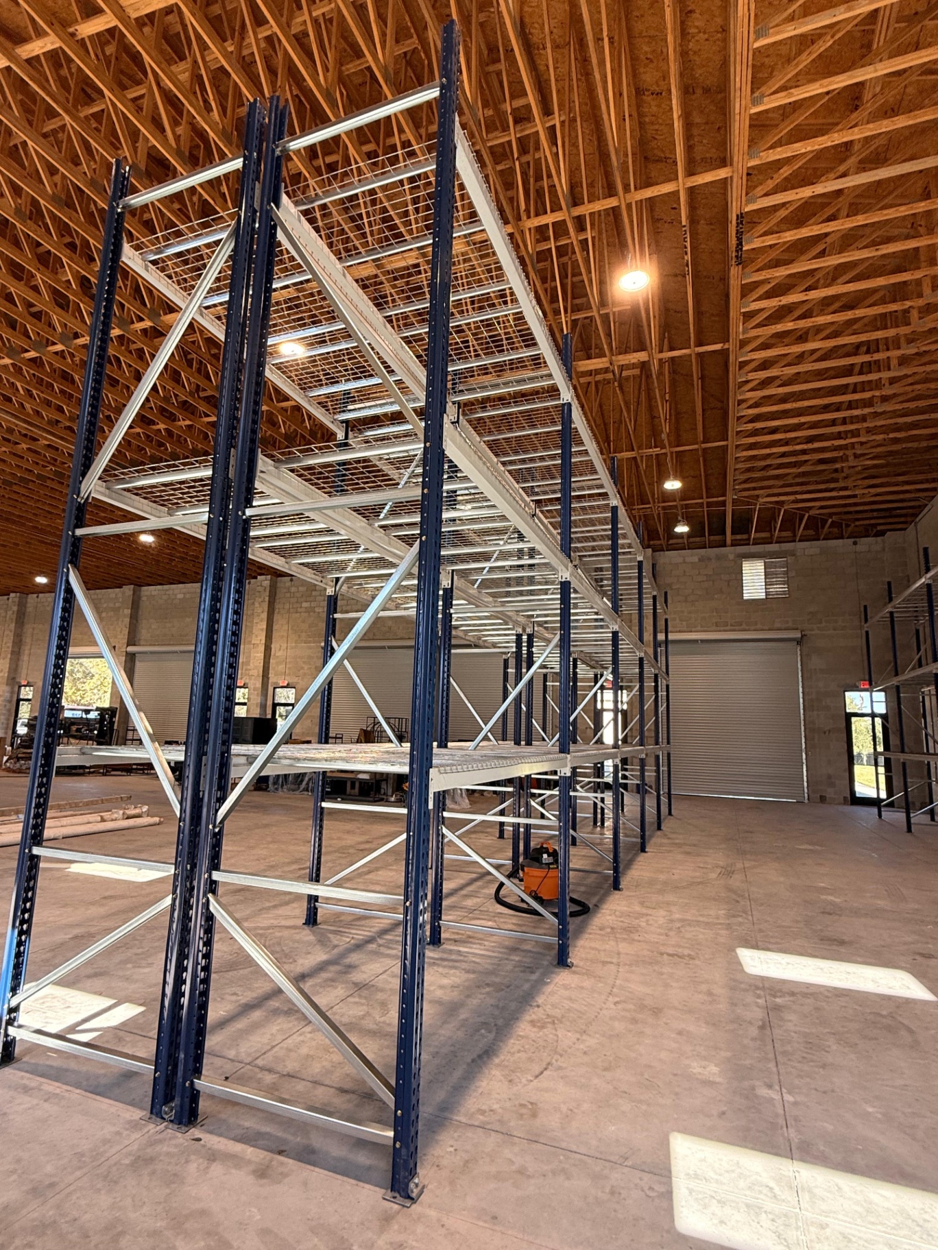 Selective pallet racking with wire decking under a wood-truss roof